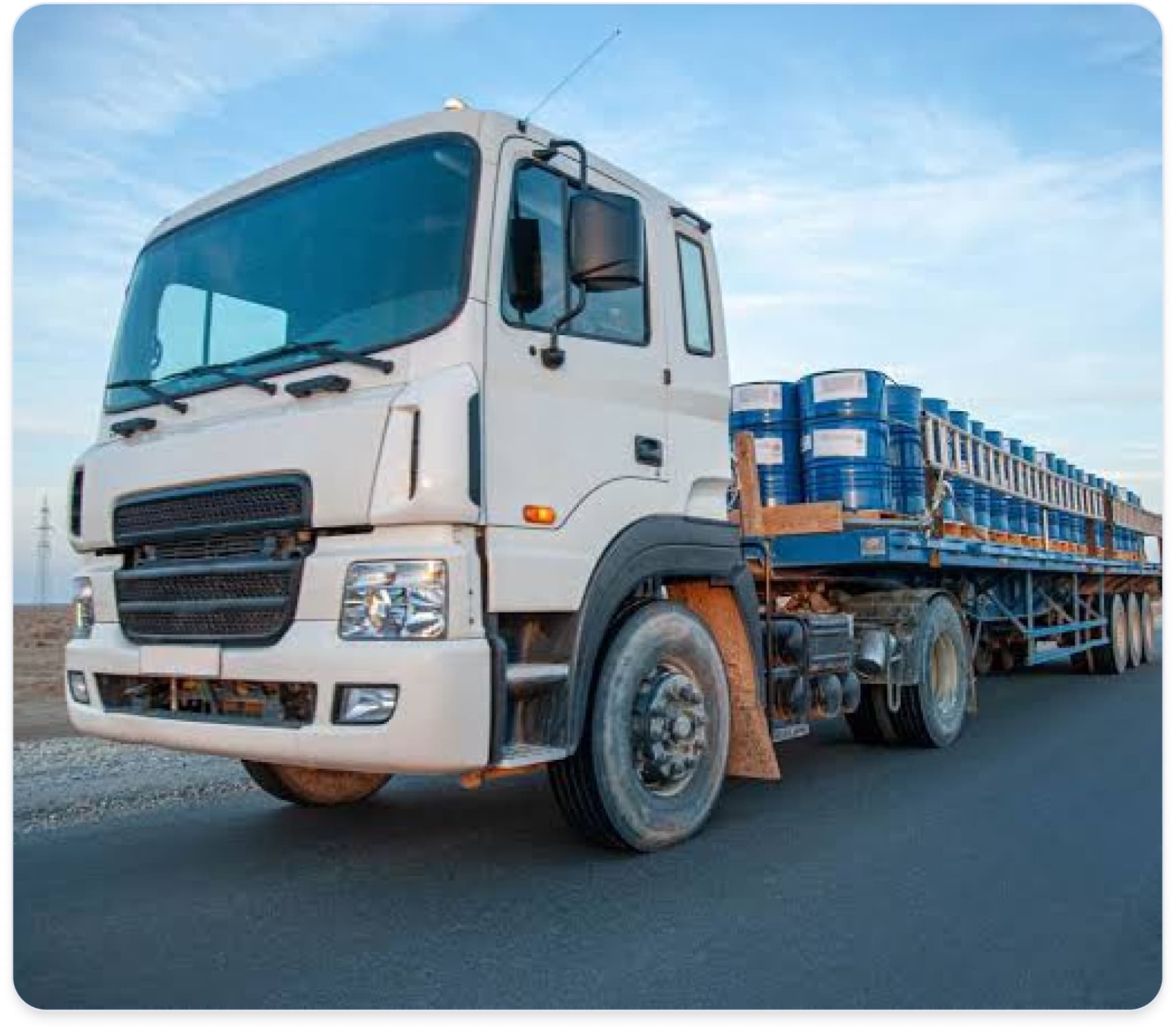 White cargo truck carrying a loaded trailer